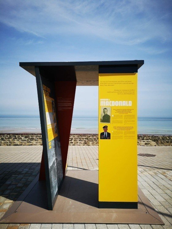 Photo d'un élément urbain faisant la promotion de l'exposition « Dans leurs pas »