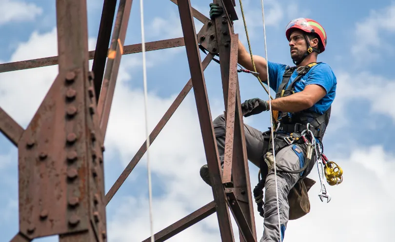 Photo d'un lignard escaladant un pylône 