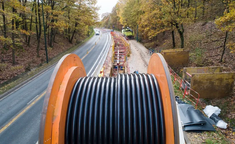 Photo de la bobine de câbles en train d'être déroulée le long de la route