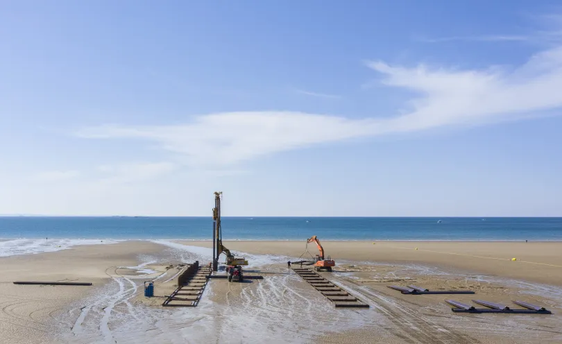 Photos d'engins de chantier en train de creuser des tranchées sur la plage