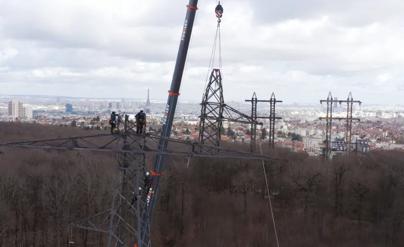 Photo du démontage d'un pylône à l'aide d'une grue