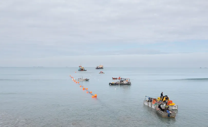Photo de bateaux intervenants dans le cadre du tirage des fourreaux en mer flottants grâce à des bouées