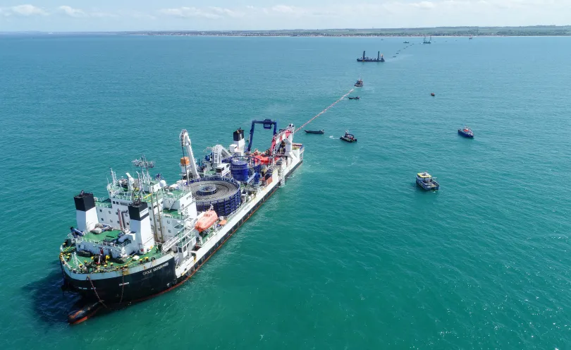 Photo d'un navire câblier en train de dérouler un câble en mer