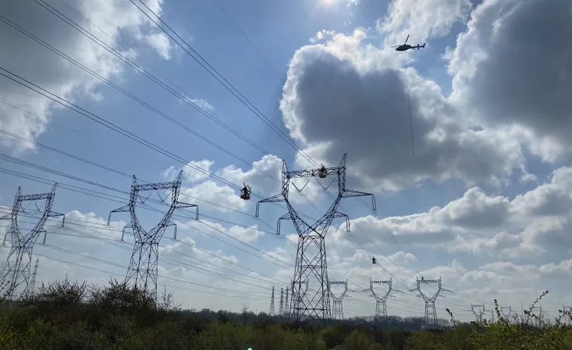 Hélicoptère survolant des pylones électriques