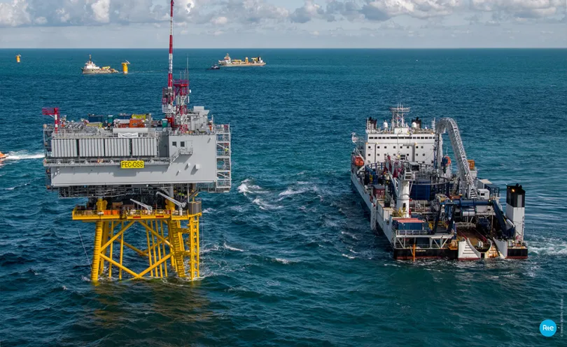 Photo de la plateforme en mer et d'un navire câblier lors de la connexion des câbles électriques