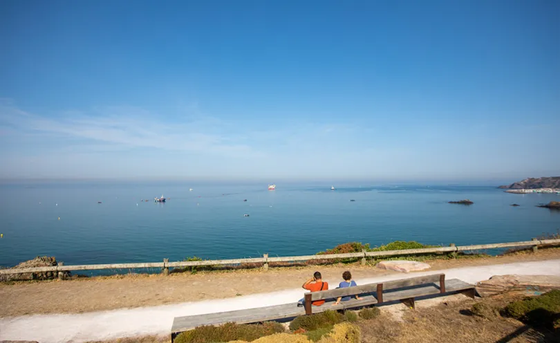 Photo du bord de mer avec au loin, le navire câblier