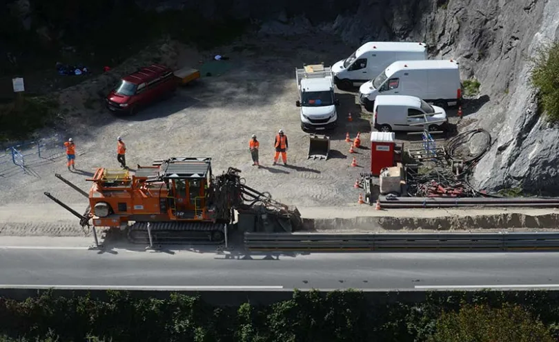 Photo d'une pelleteuse en train de creuser une tranchée avec des ouvriers surveillant les travaux