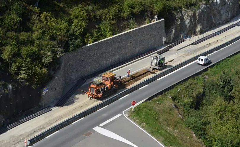 Photo d'une pelleteuse en train de creuser une tranchée le long d'une route