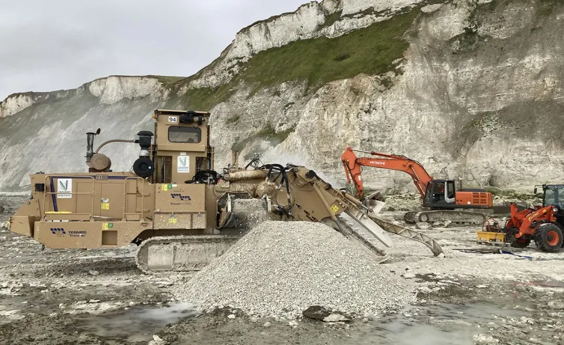 Photo de plusieurs engins sur le chantier près d'une falaise
