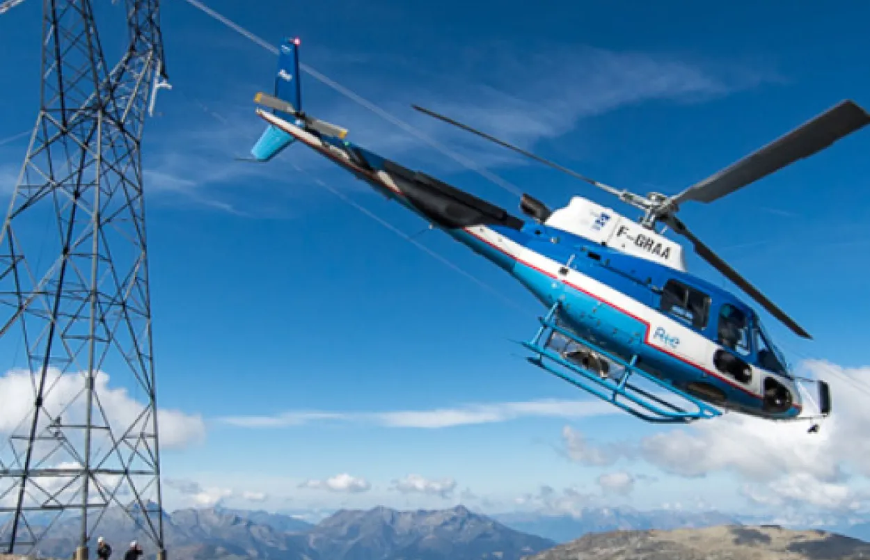 Hélicoptère survolant une ligne électrique